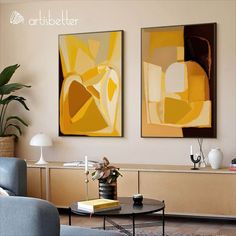 two paintings are hanging on the wall above a coffee table in a modern living room