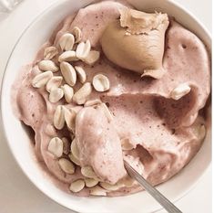 a white bowl filled with food next to a spoon