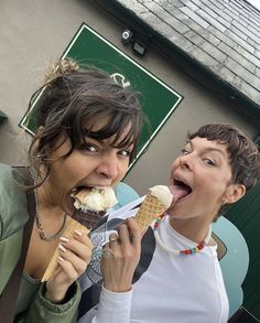 two women are eating ice cream outside