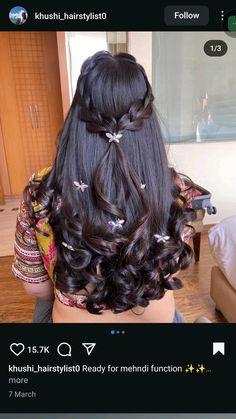 the back of a woman's head with long dark hair and butterflies on it