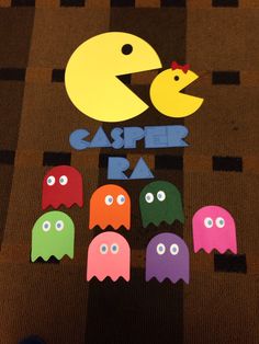 colorful paper cut outs with different shapes and sizes displayed on carpeted wall in room