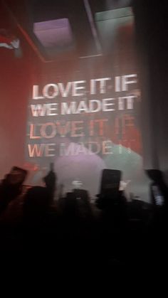 a man standing on top of a stage holding a cell phone