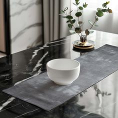 a white bowl sitting on top of a black table