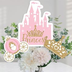 a vase filled with flowers next to a cut out of a princess's castle