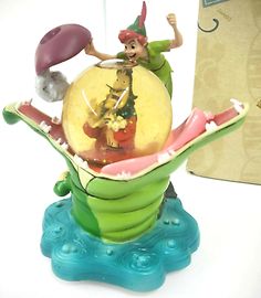 the figurine is sitting on top of a watermelon in front of a box