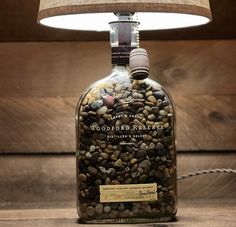 a bottle filled with rocks under a lamp