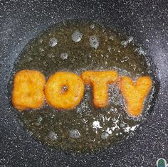 some type of food that is cooking in a frying pan with the word potty spelled out