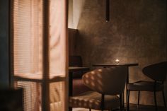 a room with a table, chairs and a candle on the table in front of it