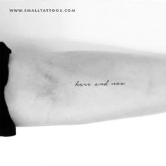 a black and white photo of a person's arm with the words here and now written on it