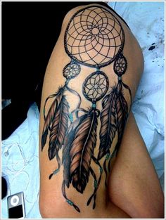 a woman's thigh with a tattoo on it that has an image of a dream catcher