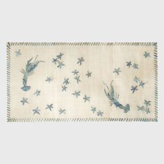 a white table cloth with blue birds and stars on the border, in front of a gray background