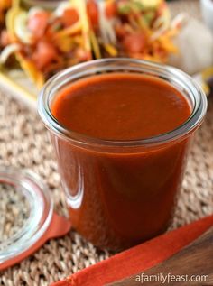 a glass jar filled with sauce sitting on top of a table