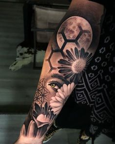 a woman's arm with flowers and a half moon tattoo on the left forearm