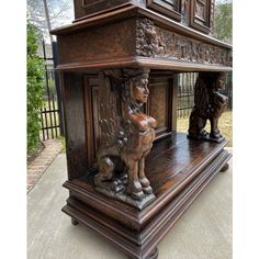 an old wooden clock with carvings on the front and sides, sitting on top of a table