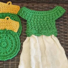 two crocheted green and yellow items sitting on top of a wicker basket