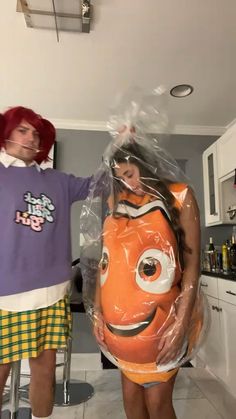 two people dressed up as characters from the movie finding nemo, one holding an inflatable pumpkin