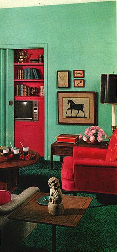 a living room with green walls and red furniture in the center, along with pictures on the wall