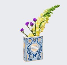 a blue and white vase with yellow flowers in it's center, on a gray background