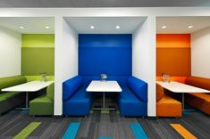 an office with brightly colored booths and tables