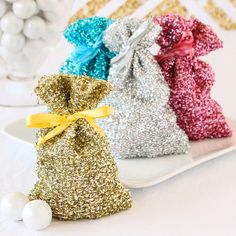 three bags filled with glitter sitting on top of a white plate next to some balls