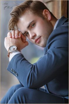 a young man in a blue suit and watch