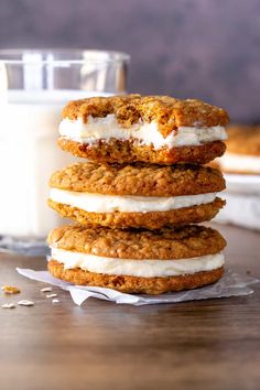 three cookies stacked on top of each other next to a glass of milk