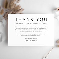 the wedding thank card is displayed next to some dried flowers and white paper with black lettering