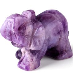 a purple elephant statue sitting on top of a white surface