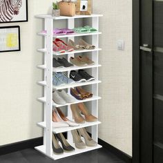 a white shoe rack with several pairs of shoes on it in front of a wall