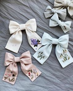 four bow ties are laid out on a bed