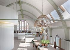 a kitchen and dining room in an open space with vaulted ceilings, white walls and wood floors