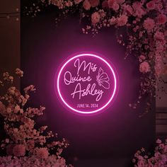 a neon sign that says mr and mrs quince adley with flowers around it