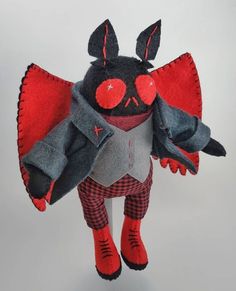 a stuffed animal with red eyes and black wings