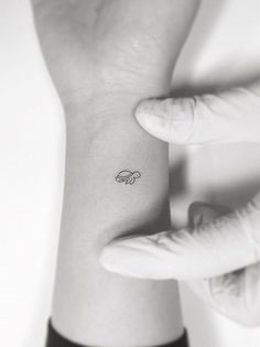 a person's wrist with a small tattoo on the left side of their arm