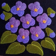 purple flowers with green leaves on a black background