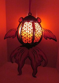 a lamp hanging from the ceiling in a room with red walls and lights on it