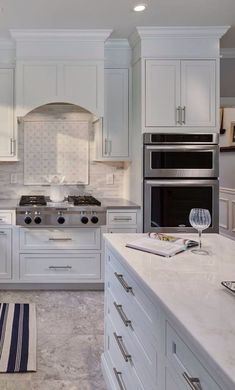 a large kitchen with white cabinets and stainless steel stove top oven, dishwasher