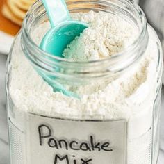 a jar filled with white powder and a blue spoon