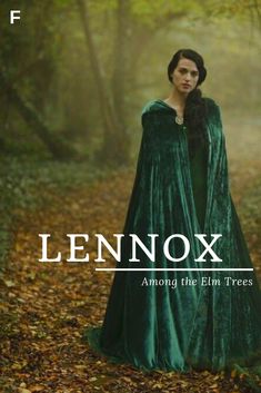 a woman in a green dress standing in the woods with leaves on the ground and text lenox among the elm trees