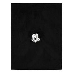 the mickey mouse towel is black and has a white face on it's side