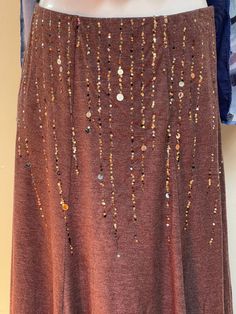 "Super fun long brown skirt with vertical lines of sparkles & tiny mirrors on the front panel. Very comfy and versatile. Back of skirt is solid.  Marked size M. The waist is elastic so it has some stretch. Would work best for S or M. Please check measurements for sizing before purchasing.  Approximate Measurements (lying flat): Waist: 14\"  Length from Waist to Bottom Hem: 30.5\" Every effort is made to accurately describe the condition of our items and their measurements. Unless otherwise noted, all clothing & accessories are pre-worn vintage and may show signs of aging. They are not brand new. All items are sold As Is and we don't accept returns. Please be sure the approximate measurements are a good fit for you. We're happy to answer questions or provide additional photos on request." Brown Stretch Party Skirt, Stretch Brown Skirt For Party, Brown Stretch Skirt For Party, Party Brown Lined Maxi Skirt, Brown Long Skirt, Long Brown Skirt, Second Anniversary Gift, Brown Skirt, What Is Advertising