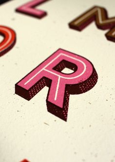 the letter p is made up of letters and numbers in pink, brown, and red