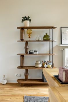 a living room filled with furniture next to a wall mounted shelf full of vases