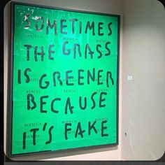 a green sign that says sometimes the grass is greener because it's fake