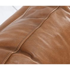 a close up view of a brown leather sofa cushion with stitching on the back