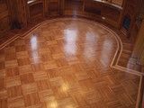 an empty room with hard wood floors and large windows on the wall, looking down