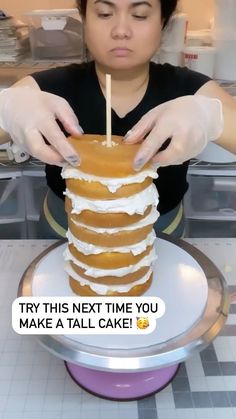 a woman is decorating a cake with icing on it and the caption says try this next time you make a tall cake