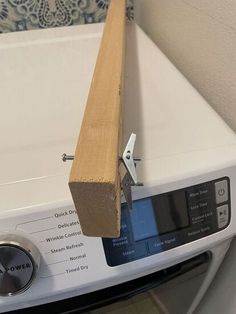 a close up of a washing machine with a wooden handle