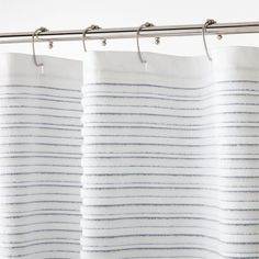 white and blue striped shower curtain hanging on a metal rod