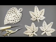 crochet leaves are being worked on with scissors and yarn, along with other items